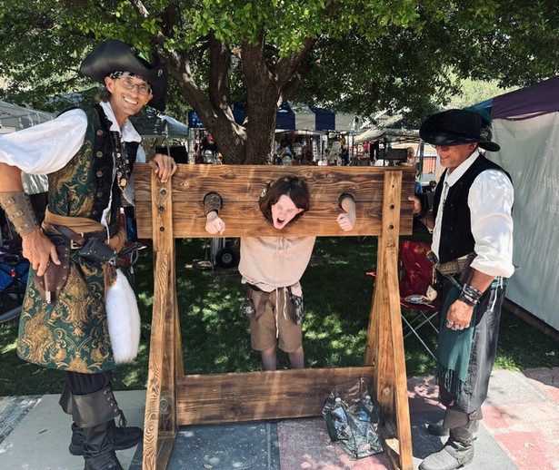 For Bisbee Pirate Weekend two pirates holding another pirate in stocks